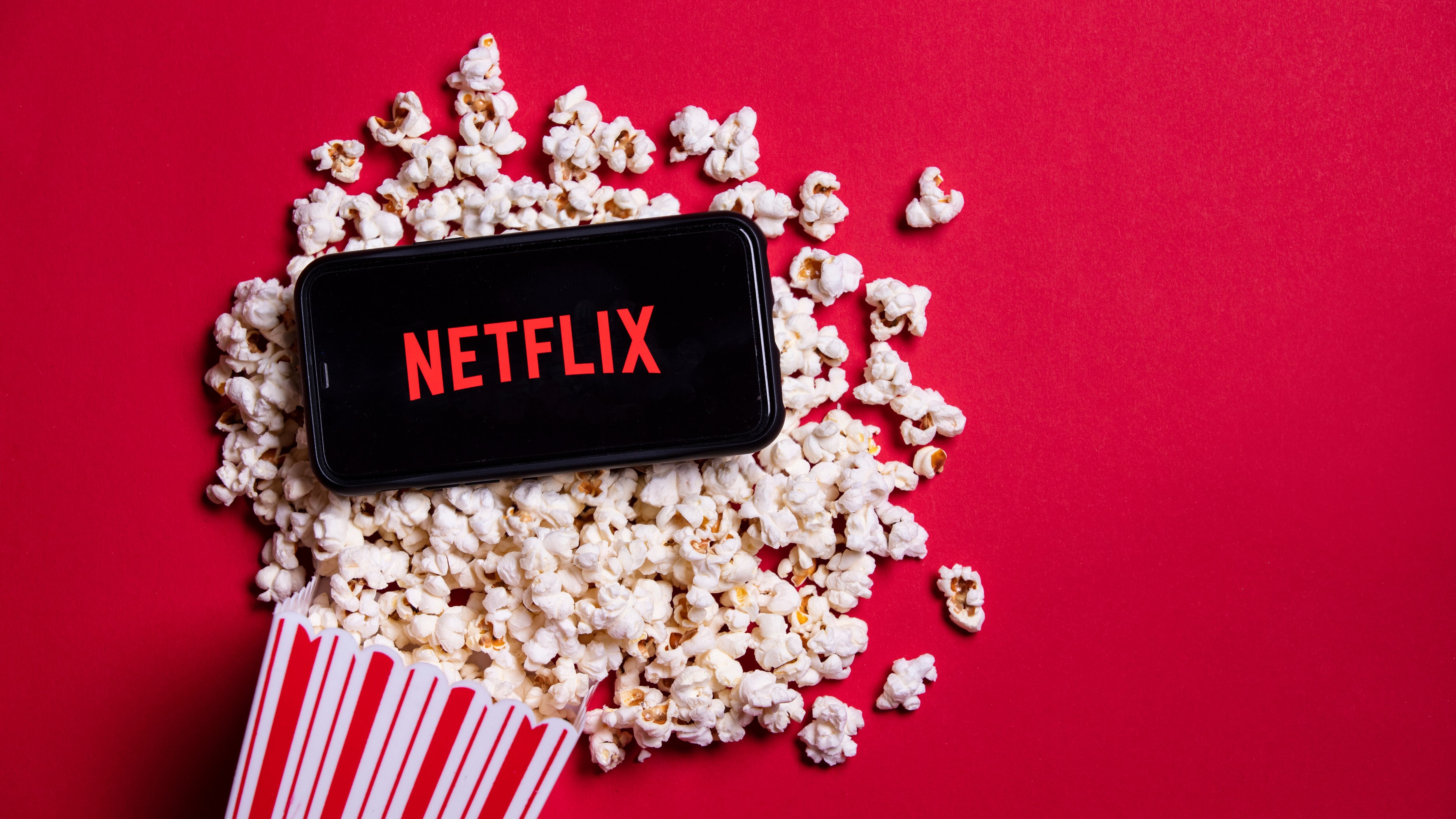 Netflix logo on a smartphone with popcorn